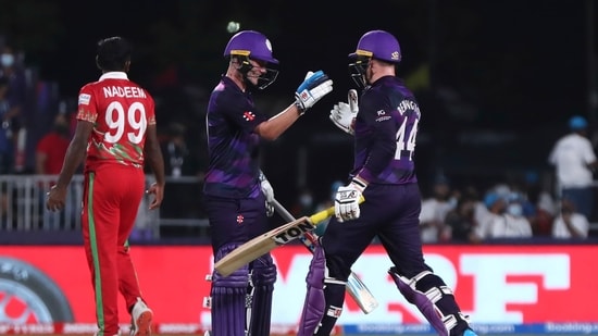 Scotland's batsman Matthew Cross, left, celebrates with teammate Richie Berrington for scoring the winning runs at the end of the Cricket Twenty20 World Cup first round match between Oman and Scotland in Muscat, Oman, Thursday, Oct. 21, 2021. Scotland beat Oman by 8 wickets with 18 balls remaining.(AP)