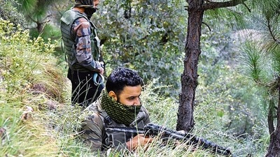 SOG personnel take positions in a forest area during the encounter, in Poonch on Friday. (PTI) SOG personnel take positions in a forest area during the encounter, in Poonch on Friday. (PTI)