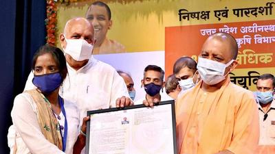 Uttar Pradesh chief minister Yogi Adityanath hands over an appointment letter to a newly selected technical assistant in the state agriculture department, in Lucknow on Friday. (PTI Photo)