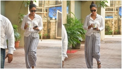 Kareena wore the white blouse with loose-fitted white and grey striped pants. She added a desi element to her OOTD by sporting gold Kohlapuri sandals with her look. (HT Photo/Varinder Chawla) Kareena wore the white blouse with loose-fitted white and grey striped pants. She added a desi element to her OOTD by sporting gold Kohlapuri sandals with her look. (HT Photo/Varinder Chawla)