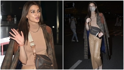 Kriti Sanon was snapped taking a flight out of Mumbai airport recently. She jetted off to London with Tiger Shroff to shoot for their next Ganapath. The star rocked a chic tan-on-tan look with a check print coat and trendy accessories. She added a dazzling twist to the airport look and was effortless as ever. (HT Photo/Varinder Chawla) Kriti Sanon was snapped taking a flight out of Mumbai airport recently. She jetted off to London with Tiger Shroff to shoot for their next Ganapath. The star rocked a chic tan-on-tan look with a check print coat and trendy accessories. She added a dazzling twist to the airport look and was effortless as ever. (HT Photo/Varinder Chawla)