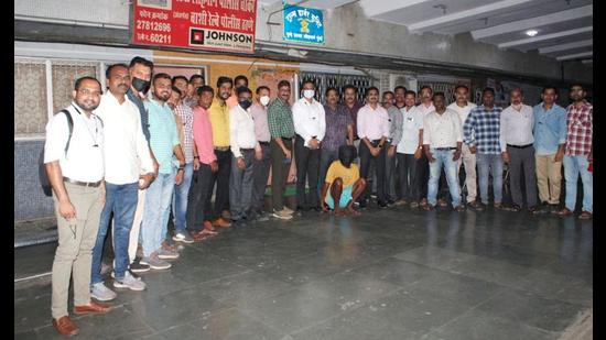 The Railway Crime Branch and Vashi GRP officials with the man (squatting) arrested for murder. (HT PHOTO)