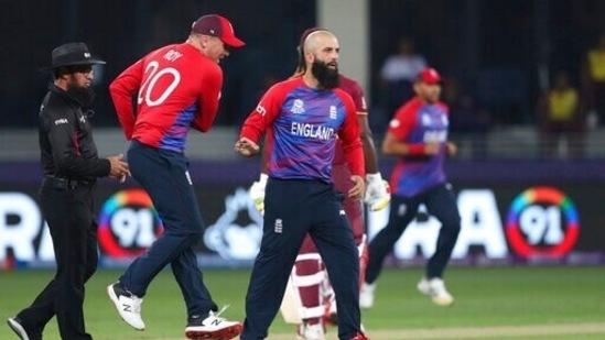 England's Moeen Ali, right, celebrates after taking the wicket of West Indies' Lendl Simmons caught by England's Liam Livingstone during the Cricket T20 World Cup match between England and the West Indies at the Dubai International Cricket Stadium, in Dubai, UAE, Saturday, Oct. 23, 2021. (AP)