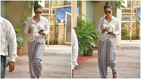 Kareena wore the white blouse with loose-fitted white and grey striped pants. She added a desi element to her OOTD by sporting gold Kohlapuri sandals with her look.(HT Photo/Varinder Chawla)