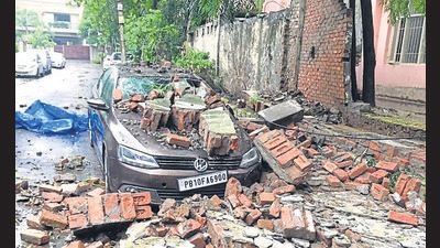 A portion of the wall of Government Senior Secondary School, Model Town, that collapsed on Sunday morning, damaging a car parked near it. (HT Photo)