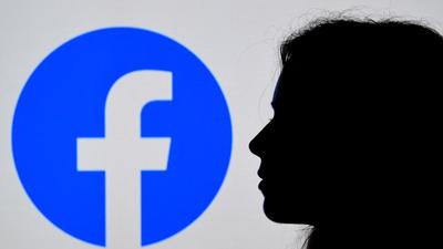 A person looks a Facebook App logo displayed on the background in Arlington, Virginia, US. Social media giant Facebook has invested way less proportionately on preventing hate-speech and misinformation on its platform for users in India, reports said. (AFP) A person looks a Facebook App logo displayed on the background in Arlington, Virginia, US. Social media giant Facebook has invested way less proportionately on preventing hate-speech and misinformation on its platform for users in India, reports said. (AFP)