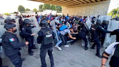 A caravan of migrants, most from Central America, break through a Mexican police barricade in Tapachula, Mexico, Saturday, Oct. 23, 2021. Immigration activists say they will lead migrants out of the southern Mexico city of Tapachula Saturday at the start of a march they hope will bring them to Mexico City to press their case for better treatment. (AP Photo/ Edgar H. Clemente) (AP)