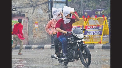 Residents braving the rain in Ludhiana on Sunday. (Harsimar Pal Singh/HT)