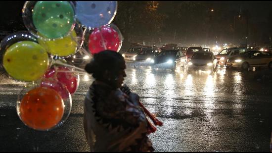 A balloon seller caught in sudden rain at Rajendra Nagar in New Delhi. (Sanchit Khanna/ Hindustan Times)