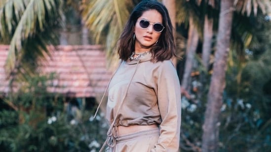 Completing her attire with a pair of spotless white sneakers, Sunny opted for a dewy makeup look, left her blow-dried tresses open down her shoulders and accessorised her look with a pair of black sunglasses, link-chain neckpieces and a stack of finger rings.(Instagram/sunnyleone)
