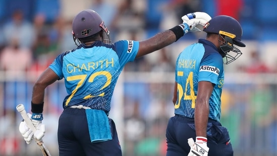 Sri Lanka's Charith Asalanka, left, gestures to his teammate Bhanuka Rajapaksa as he walks from the field during the Cricket Twenty20 World Cup match between Sri Lanka and Bangladesh in Sharjah, UAE, Sunday, Oct. 24, 2021. (AP)
