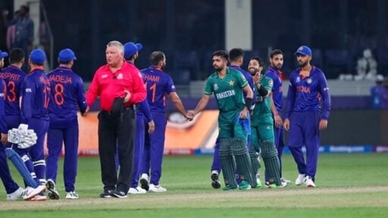 Indian, in blue, and Pakistan's cricketers greet each other at the end of the Cricket Twenty20 World Cup match between India and Pakistan in Dubai, UAE, Sunday, Oct. 24, 2021. (AP Photo/Aijaz Rahi)(AP)