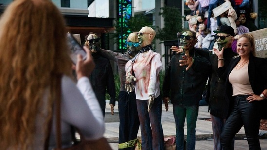 A women poses for a picture with zombie figures put on display at a shopping centre as part of the Halloween season decorations, in San Pedro Garza, Nuevo Leon State, Mexico.(AFP)