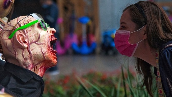 A woman observes a zombie figure put on display at a shopping centre as part of the Halloween season decorations, in San Pedro Garza, Nuevo Leon State, Mexico.(AFP)