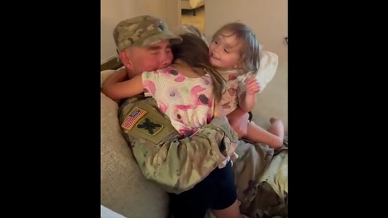 Man embraces his daughters in a fierce embrace. Screengrab