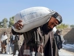 Afghan people carry sacks of food grains distributed as aid by the World Food Programme (WFP) in Kandahar. Afghan people carry sacks of food grains distributed as aid by the World Food Programme (WFP) in Kandahar.