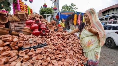 A vendor arranges earthen lamps at her shop ahead of Diwali in Ahmedabad on Monday. (PTI Photo) A vendor arranges earthen lamps at her shop ahead of Diwali in Ahmedabad on Monday. (PTI Photo)