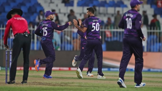 Scotland's Safyaan Sharif, center, celebrates with teammates the dismissal of Afghanistan's Mohammad Shahzad during the Cricket Twenty20 World Cup match between Afghanistan and Scotland in Sharjah, UAE, Monday, Oct. 25, 2021.(AP)