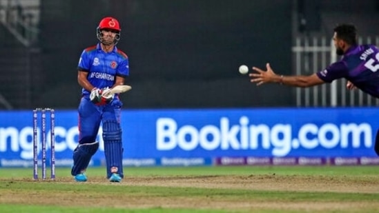 Afghanistan's Najibullah Zadran plays a shot as Scotland's Safyaan Sharif tries to stop during the Cricket Twenty20 World Cup match between Afghanistan and Scotland in Sharjah, UAE, Monday, Oct. 25, 2021. (AP Photo/Aijaz Rahi)(AP)