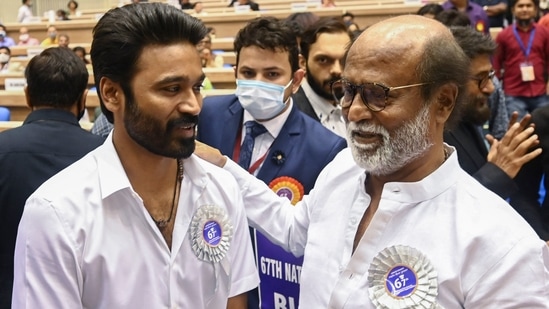 Actors Dhanush and Rajinikanth pose for a photograph during the 67th National Film Awards and Dadasaheb Phalke Awards 2019. (AFP)