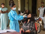 A health worker collects swab sample of a resident for Covid test in Mumbai on Tuesday.(PTI) A health worker collects swab sample of a resident for Covid test in Mumbai on Tuesday.(PTI)
