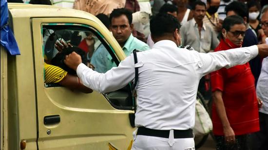 A traffic police personnel stops a mini-truck in Kolkata. The Kolkata Police have intensified their crackdown on instances of people not wearing face masks with Covid-19 cases in the city going up after the Durga Puja festival. (ANI)