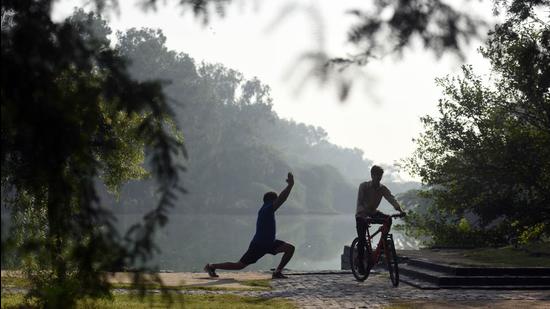 A man performs yoga on a hazy morning at Sanjay Lake in New Delhi. (Raj K Raj/HT Photo)