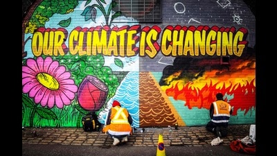 Street artists paint a mural on a wall opposite the COP26 climate summit venue in Glasgow, October 13, 2021 (AFP) Street artists paint a mural on a wall opposite the COP26 climate summit venue in Glasgow, October 13, 2021 (AFP)
