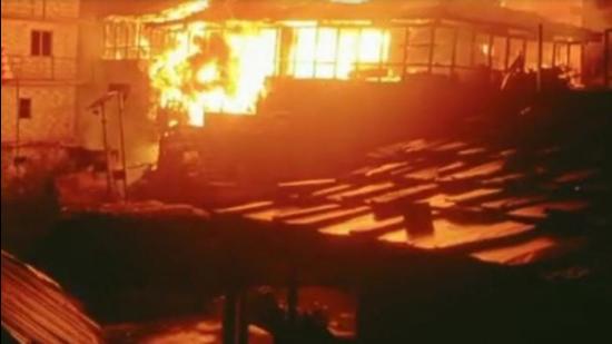 The fire raging through houses in the remote village of Malana in Kullu district of Himachal Pradesh on Tuesday night. (HT Photo)