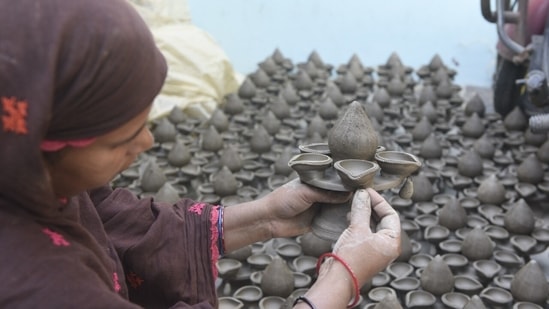 The family consists of 30 members including children who work together to prepare earthen lamps ahead of the most awaited Hindu festival, Diwali.(HT Photo/Deepak Gupta)