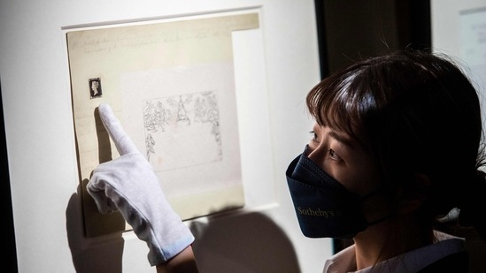A staff member points to the world's first postage stamp, the Penny Black(AFP)