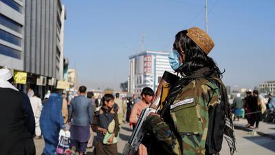 People walk past Bader, 21, a Taliban fighter, at the market in Kabul, Afghanistan. India is concerned about the current situation in Afghanistan, a top Pentagon official said. (REUTERS)