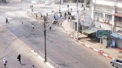In an image from video obtained by The Associated Press, soldiers, upper right, chase protesters in Yangon, Myanmar on March 3, 2021. (AP Photo)
