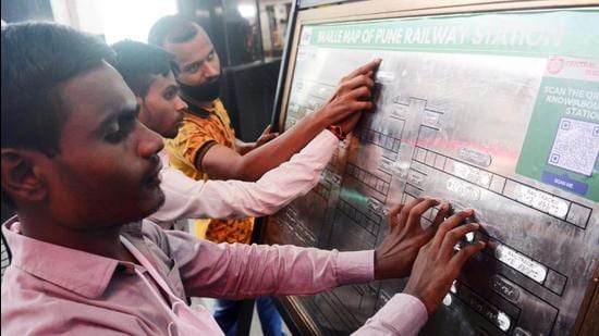 The visually impaired read the Braille map at Pune railway station on Thursday. To help visually challenged passengers at the Pune railway station, the Pune railway has installed a Braille layout of the station premises. (HT)