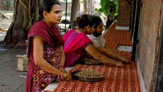 Visually impaired girls make earthen lamps for the upcoming Diwali festival, inside Andh Kanya Prakash Gruh in Ahmedabad.(PTI)