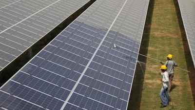 Workers clean photovoltaic panels inside a solar power plant. US company First Solar will invest $684mn in Tamil Nadu for a solar photovoltaic (PV) thin film module manufacturing facility that will support 1,000 jobs, with 60% of them women. (REUTERS) Workers clean photovoltaic panels inside a solar power plant. US company First Solar will invest $684mn in Tamil Nadu for a solar photovoltaic (PV) thin film module manufacturing facility that will support 1,000 jobs, with 60% of them women. (REUTERS)