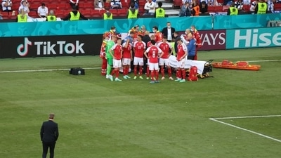 Christian Eriksen receives medical attention after collapsing during the match.