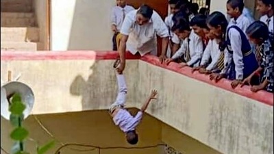 A screengrab of the viral video showing Vishwakarma dangling the child. (ANI)