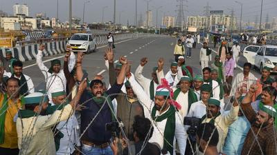 Farmers raise slogans as police remove barricades from the farmers' protest site at Ghazipur border in New Delhi, Friday. (REPRESENTATIONAL IMAGE/PTI)