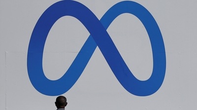 A man stands in front of a sign of Meta, the new name for the company formerly known as Facebook, (REUTERS)
