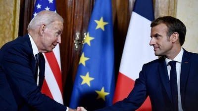 French President Emmanuel Macron (R) and US President Joe Biden (L) shake hands during their meeting at the French Embassy to the Vatican in Rome. (AFP)