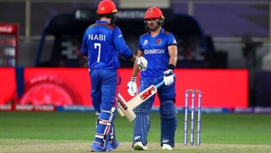 Afghanistan's Gulbadin Naib, right, and captain Mohammad Nabi celebrate scoring runs during the Cricket Twenty20 World Cup match between Pakistan and Afghanistan in Dubai, UAE, Friday, Oct. 29, 2021. (AP Photo/Aijaz Rahi)(AP)