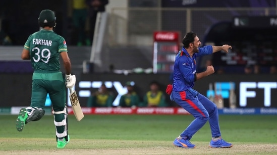 Afghanistan's captain Mohammad Nabi, right, celebrates the dismissal of Pakistan's Fakhar Zaman, left, during the Cricket Twenty20 World Cup match between Pakistan and Afghanistan in Dubai, UAE, Friday, Oct. 29, 2021. (AP Photo/Aijaz Rahi)(AP)