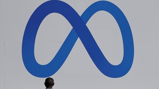 A man stands in front of a sign of Meta, the new name for the company formerly known as Facebook,(REUTERS)