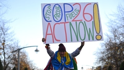 An activist holds up a placard outside the venue for UN climate summit in Glasgow on Saturday. (Photo by Ben STANSALL / AFP) (AFP) An activist holds up a placard outside the venue for UN climate summit in Glasgow on Saturday. (Photo by Ben STANSALL / AFP) (AFP)