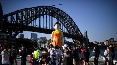 In Sydney, a 4.5 metre tall replica doll from the Squid Game has been installed at the harbour and fans and rushing to take pictures with it. (AFP Photo)