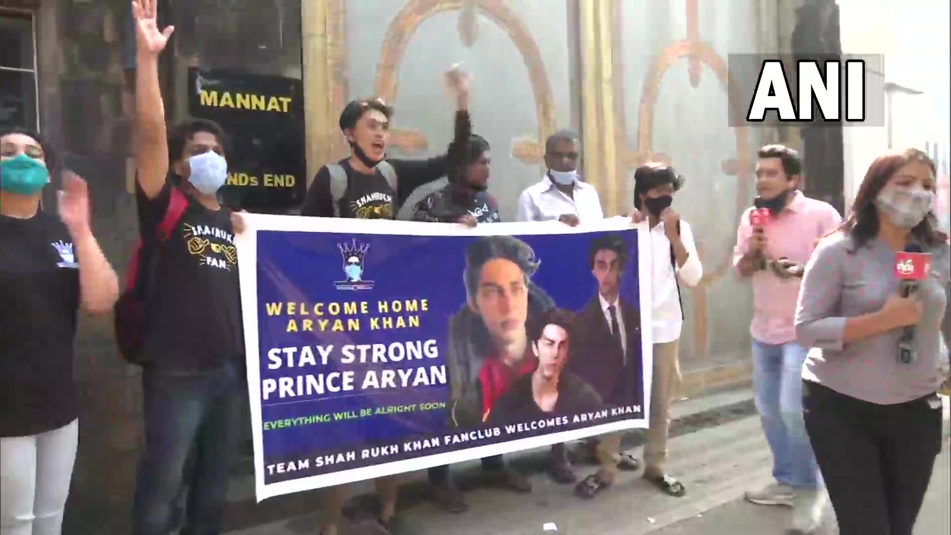 Fans carrying banners outside Mannat.