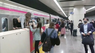 People escape through windows of a Tokyo train line following a knife, arson and acid attack, in Tokyo, Japan.&nbsp; (TWITTER / @SIZ33/via REUTERS)
