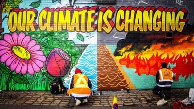 Street artists paint a mural on a wall opposite the COP26 climate summit venue in Glasgow (AFP) Street artists paint a mural on a wall opposite the COP26 climate summit venue in Glasgow (AFP)