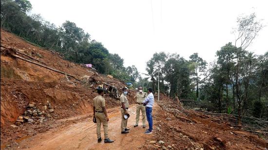 Policemen and other officials inspect Kokkayar, one of the landslide-affected areas, in Idukki district. (Vivek R Nair/HT Photo)